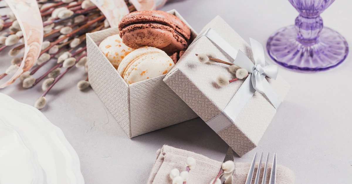 A colourful assortment of French macarons neatly arranged inside a stylish, custom-printed white macaron box.
